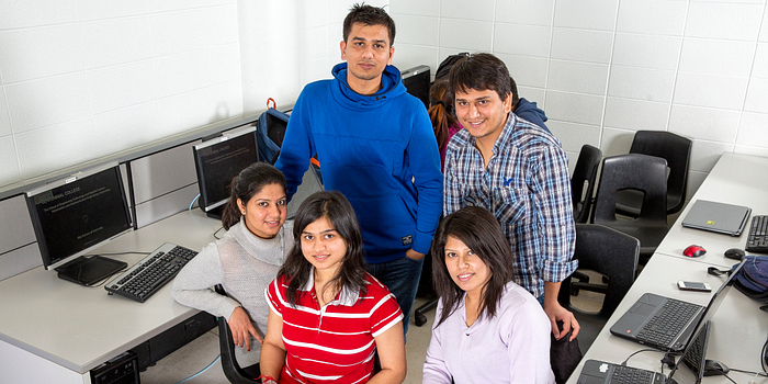 picture of centennial college students looking at the extended enrolment services hours for winter registration